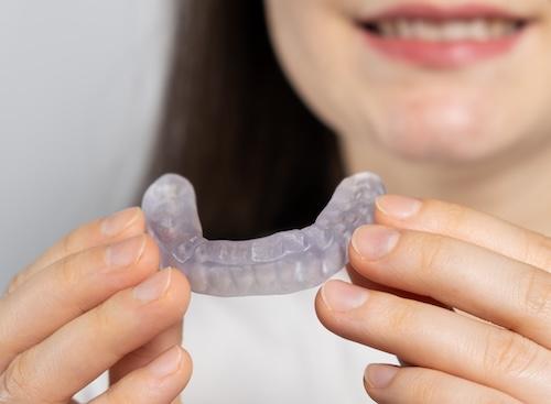 An image of a woman holding clear veneers in Wahroonga, NWS